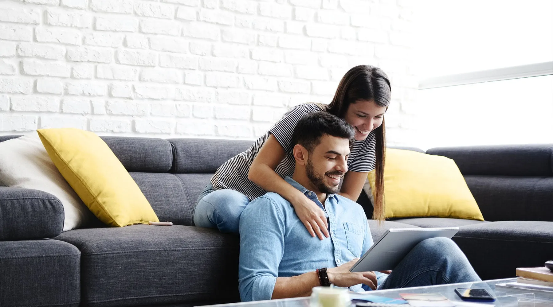 A couple on their sofa going through options together on a tablet