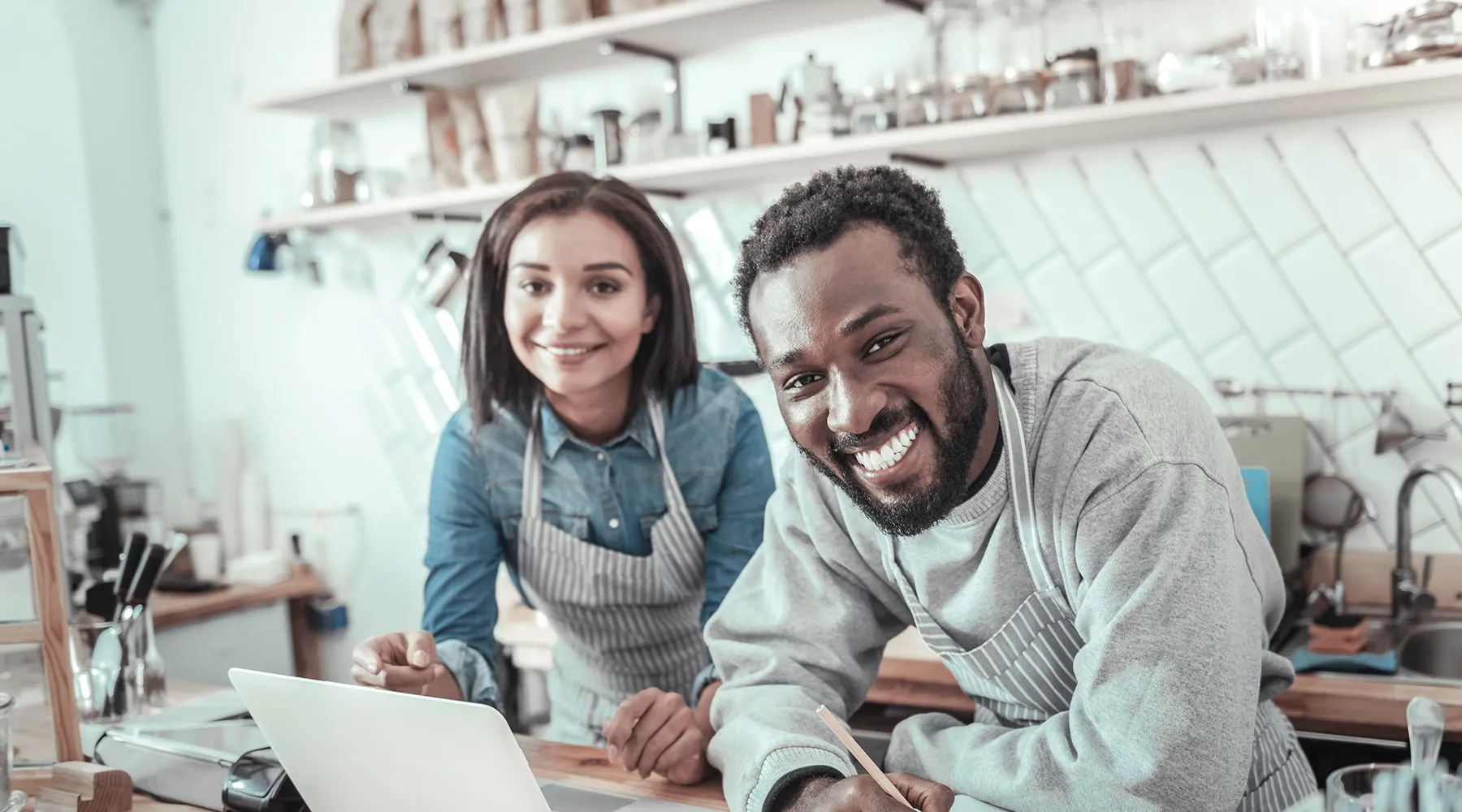 Two small business owners at their counter with a laptop